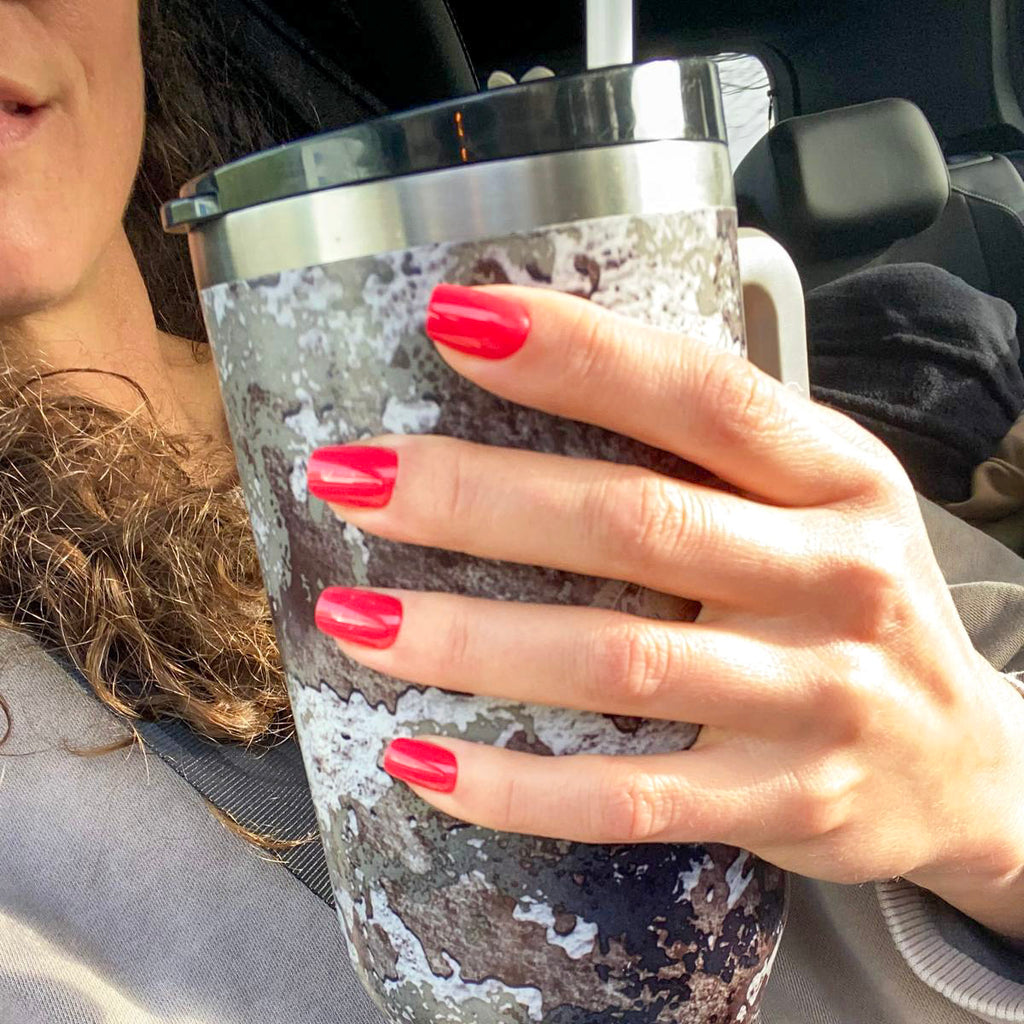 Manucure press-on Corail Rosé carrés courts, main tenant une thermos camouflage en voiture, faux ongles rouge-corail vif et dynamiques LYLY Nails