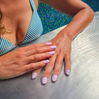 Press-on nails Rose Dragée arrondi courts deux mains posées au bord d'une piscine en été, LYLY Nails