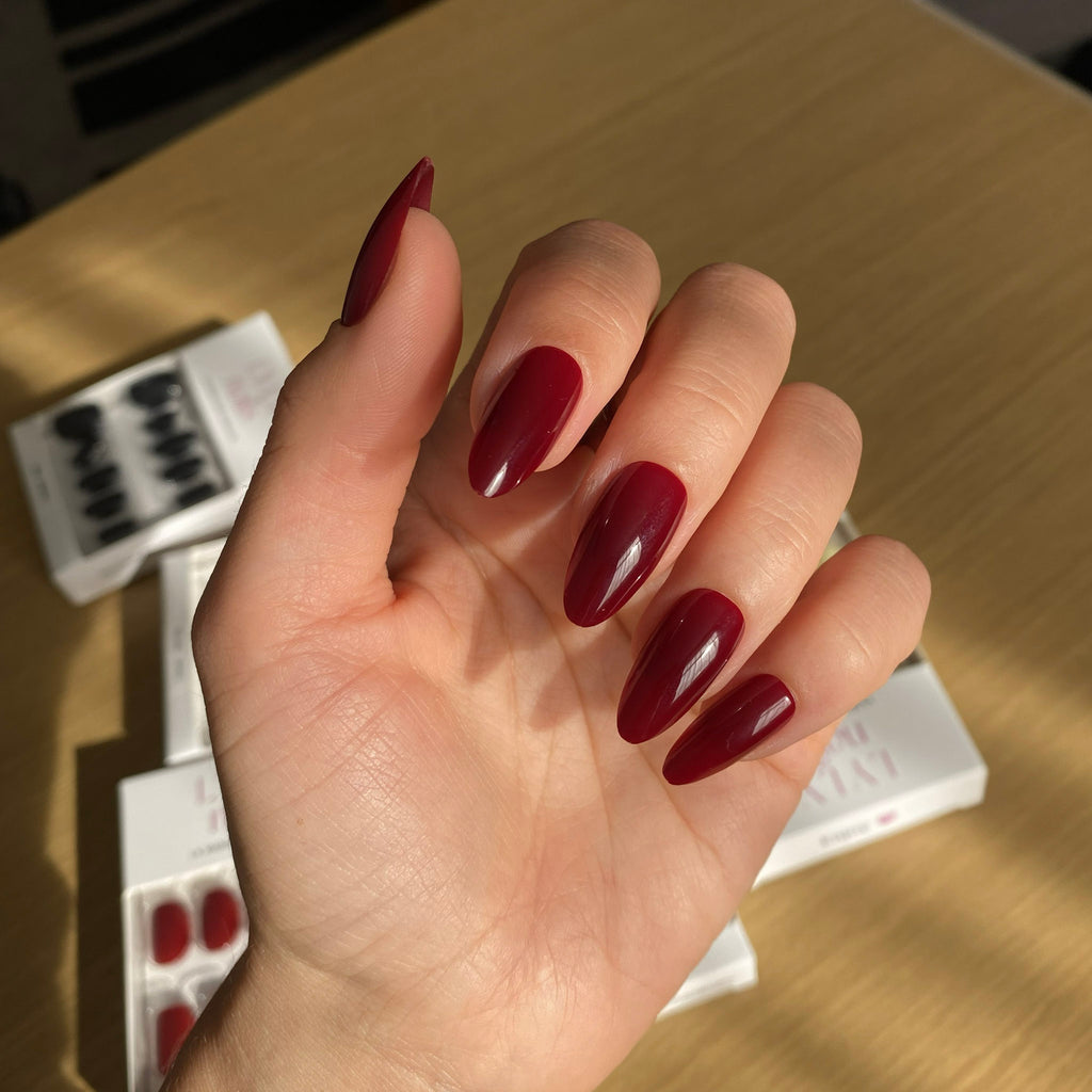 Manucure Press-on Nails Rouge Cerise forme amande moyenne, teinte profonde et envoûtante portée au quotidien LYLY Nails