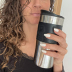 Faux ongles Blanc Crème amande courts sur main tenant une thermos à café, cheveux bouclés et tenue casual chic, ongles blanc crème naturel LYLY Nails