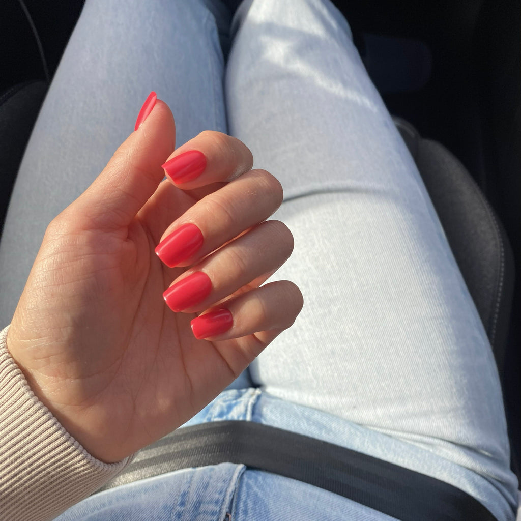 Press-on Nails Corail Rosé carrés courts en voiture au soleil, jean clair et pull crème, manucure corail estivale et fraîche LYLY Nails