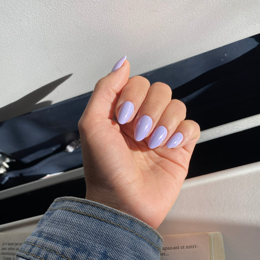 Faux ongles Lavande Douce forme amande courte, manucure posée dans l'avion, veste denim et livre, manucure lilas lumineuse et fraîche LYLY Nails