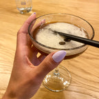 Press-on Nails Lilas Pastel amande courts sur main tenant un espresso martini, ambiance bar tendance, ongles faux violets doux et féminins LYLY Nails