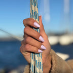 Faux ongles Lilas Pastel forme amande courte portés sur voilier, cordages nautiques et ciel bleu en fond, manucure pastel estivale et lumineuse LYLY Nails