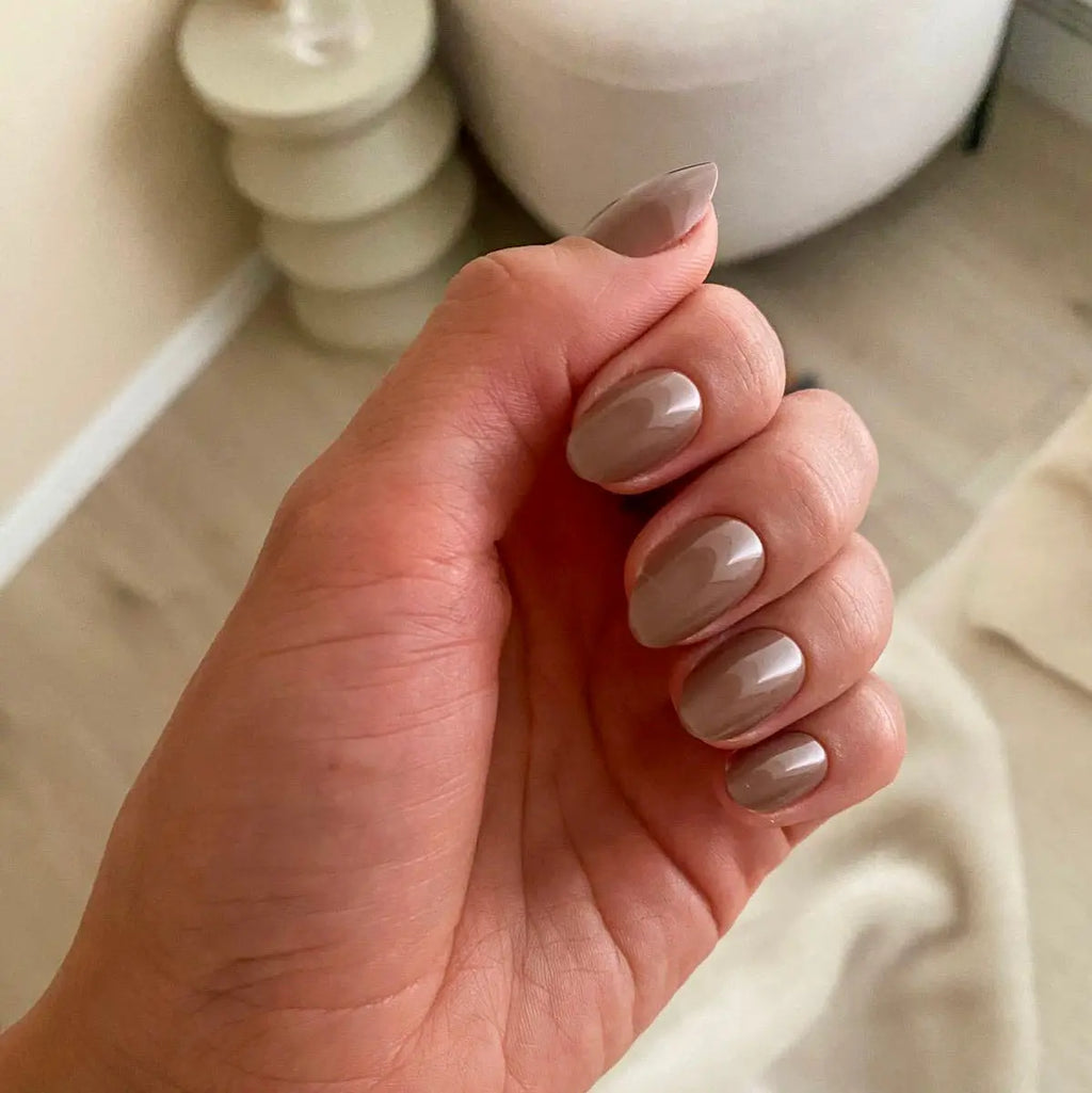 Press-on nails Marron Glacé amande courts poing fermé dans un intérieur cosy avec bougies, LYLY Nails