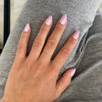 Press-on Nails Rose Orchidée amande courts portés sur main posée, bague fine dorée, pull gris doux, faux ongles rose nacré lumineux et féminins LYLY Nails