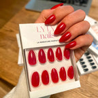 Faux ongles Rouge Coquelicot amande courts portés sur main tenant le kit LYLY Nails, ongles assortis au packaging, manucure rouge éclatante et soignée LYLY Nails