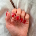 Press-on nails Rouge Tomate arrondi courts main posée sur tissu lin beige, LYLY Nails
