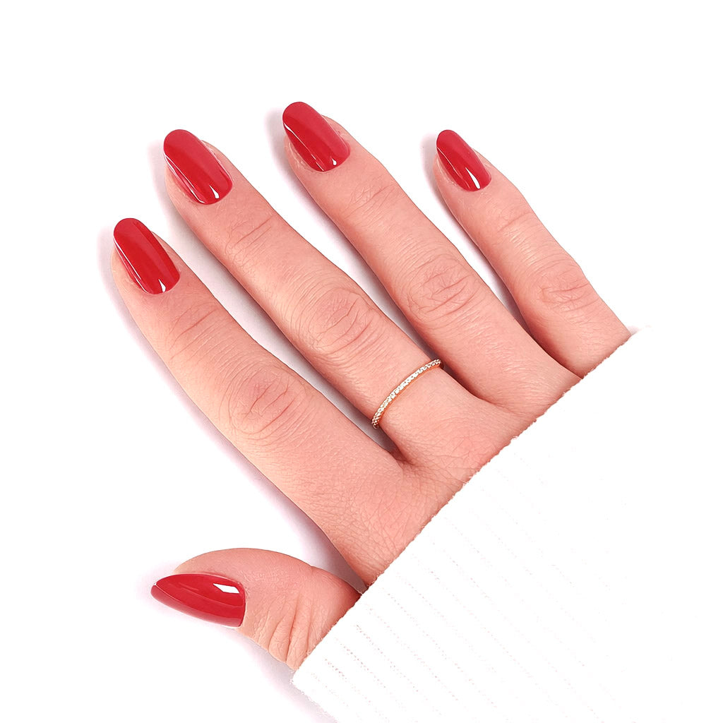 Gros plan manucure Press-on Nails Rouge Tomate — forme arrondie courte portée sur main LYLY Nails