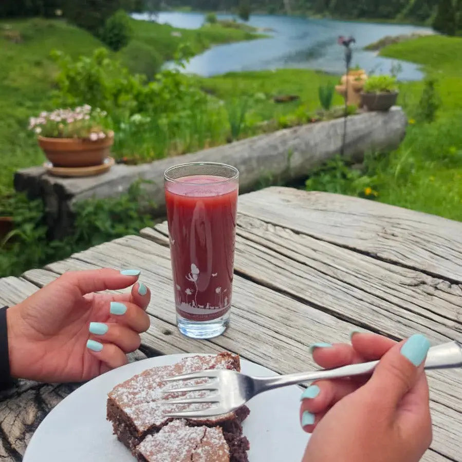 Press-on Nails Vert Lagon carrés courts, deux mains sur table rustique en terrasse, thé froid maison et brownie, rivière et verdure en fond, faux ongles frais et estivaux LYLY Nails